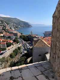 High angle view of townscape by sea against sky