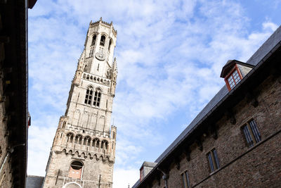 Belfry of bruges against blue sky and white cloud