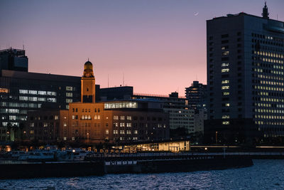 View of buildings at waterfront at sunset