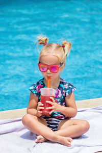 Full length of girl sitting in swimming pool