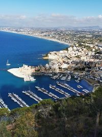 High angle view of townscape by sea against sky