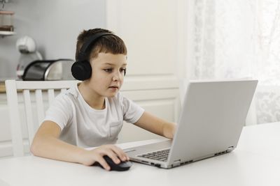 Young man using mobile phone while sitting on table