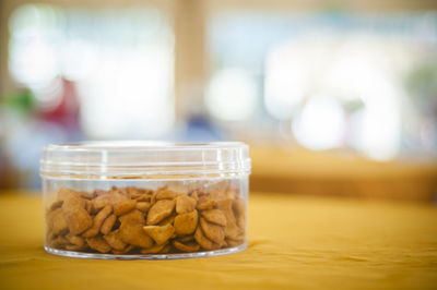 Crackers in plastic container on table