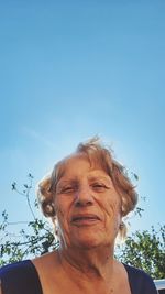 Low angle view of young man against clear blue sky