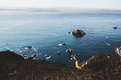 High angle view of rocks on sea against sky