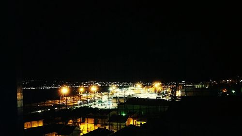 High angle view of illuminated buildings against sky at night