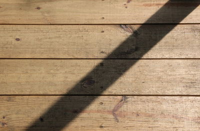 High angle view of shadow on wooden wall
