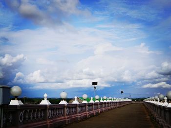 Street by bridge against sky