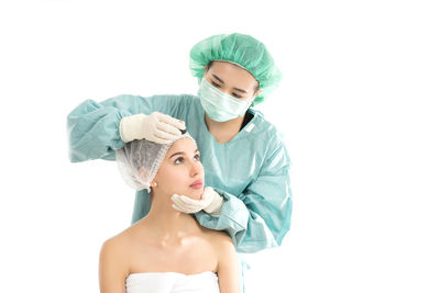 Surgeon with patient against white background