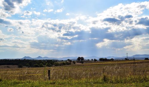 Scenic view of field against cloudy sky