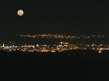 Illuminated city against sky at night