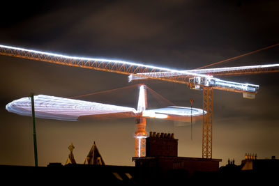 Illuminated traditional windmill against sky at night