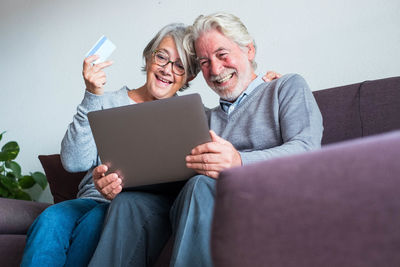 Friends sitting on sofa at home