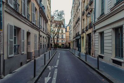 Empty road along buildings