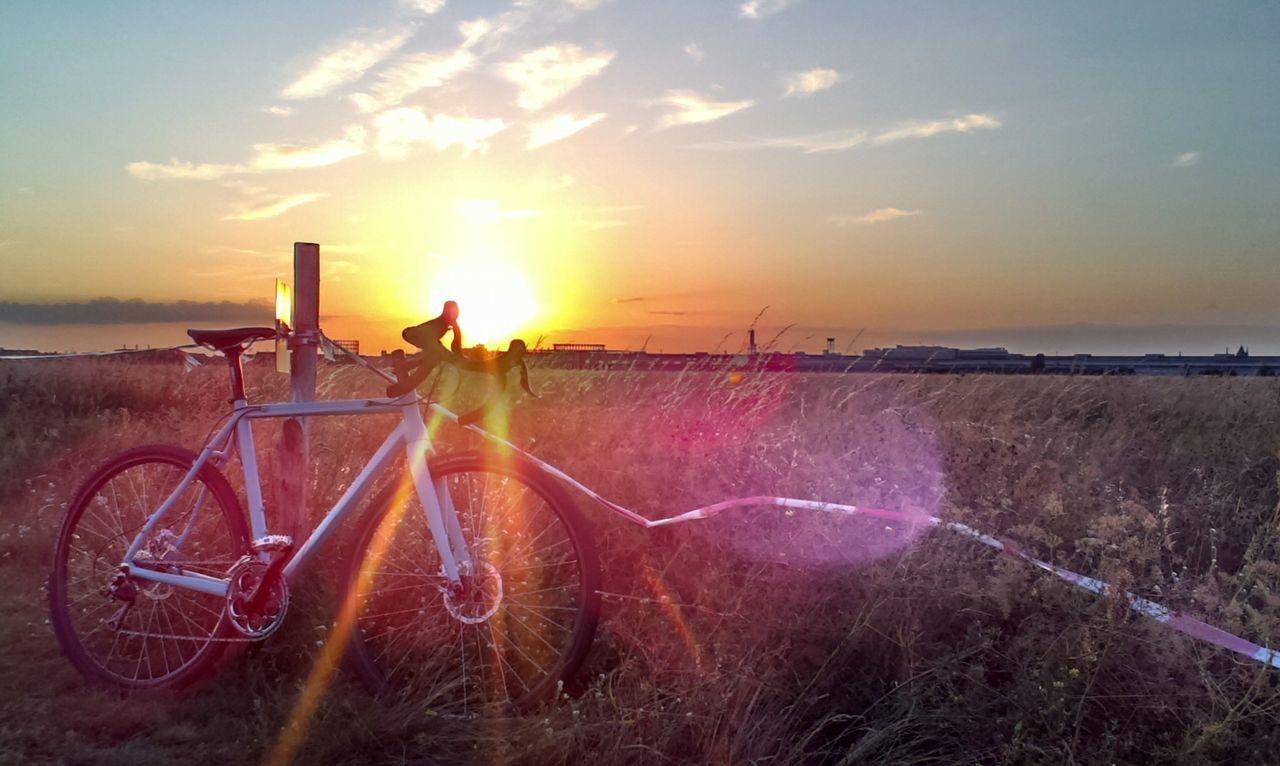 sky, sunset, bicycle, sun, scenics, tranquil scene, sea, water, tranquility, beach, sunlight, grass, beauty in nature, horizon over water, cloud - sky, nature, transportation, field, land vehicle, shore