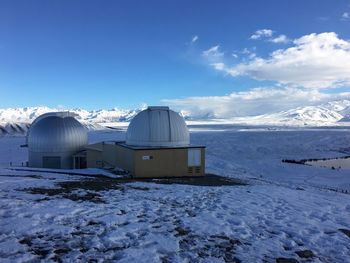 Winter snow view from the top of a sky observatory with big telescopes and snow-capped mountains.