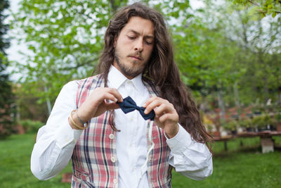 Young man holding bow tie