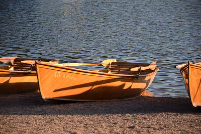 Boats moored on shore by lake