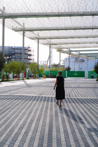 Full length of woman walking on sidewalk