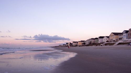 Scenic view of beach against clear sky during sunset