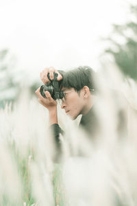 Portrait of man with his camera in the middle of white reeds