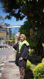 Portrait of woman standing against plants