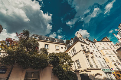 Low angle view of trees and buildings against sky