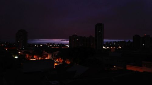 Illuminated cityscape against sky at night