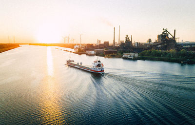 Nautical vessel sailing in sea against sky during sunset