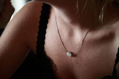 Close-up of silver necklace with white gemstone