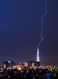 Illuminated buildings in city against sky at night