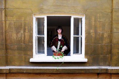 Portrait of woman standing in window