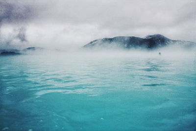 Scenic view of hot spring against mountains