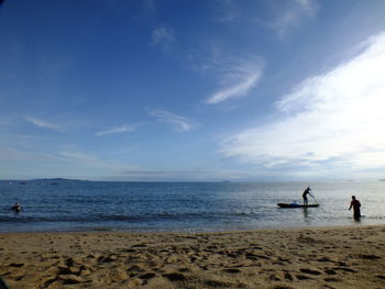 People at beach against sky