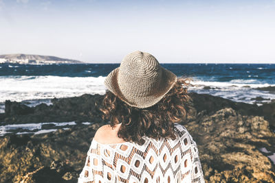 Rear view of woman looking at sea shore against sky