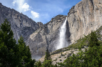 Low angle view of waterfall against sky