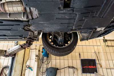 Car chassis on the lift, view from the bottom. visible exhaust system, wheels, brake hoses.