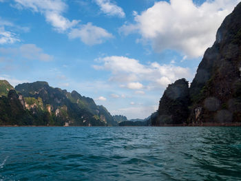 Scenic view of sea and mountains against sky