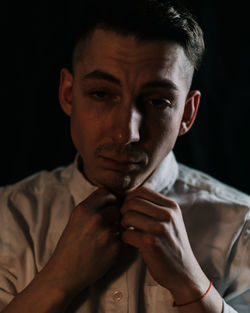 Close-up portrait of young man against black background