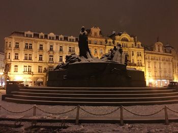 Statue in city at night