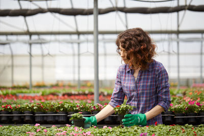 Beautiful woman working in greenhouse