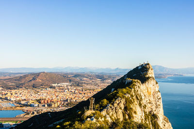 Aerial view of townscape by sea against clear sky