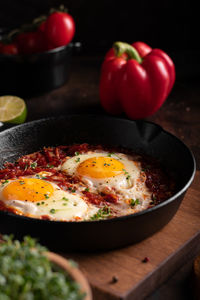 Breakfast with shakshouka and vegetables on a wooden table close up image