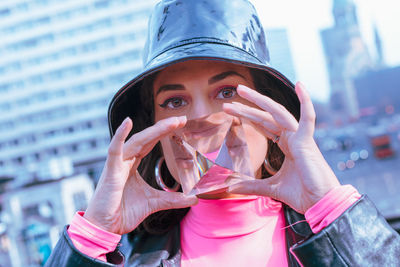 Portrait of young woman holding crystal in city