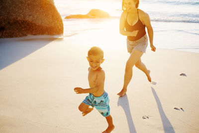 Mother and son running at beach