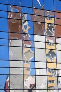 Low angle view of glass building against sky