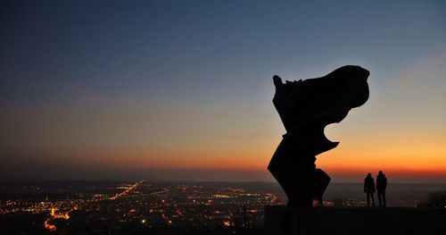 Silhouette of man in sea against sky at night