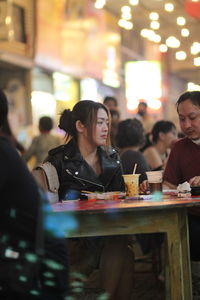 A woman and a man sitting in a food court eating
