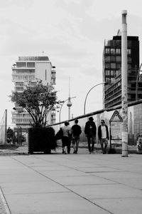 People on street in city against sky