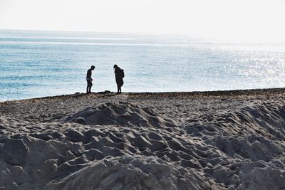 People on beach against clear sky